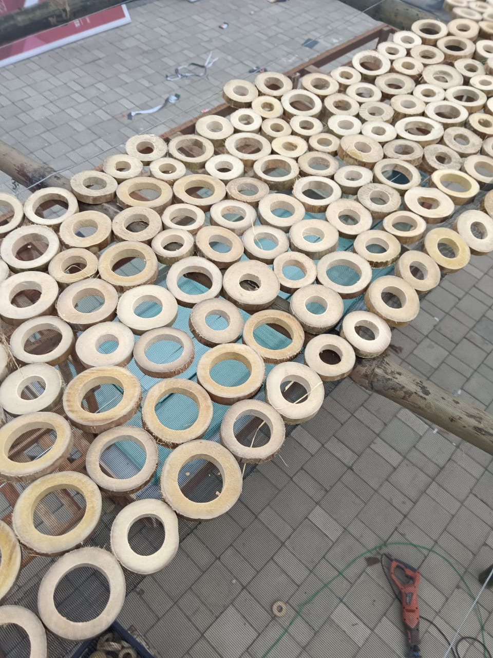Close-up of hundreds of bamboo cross-section rings laid on wire mesh forming the canopy