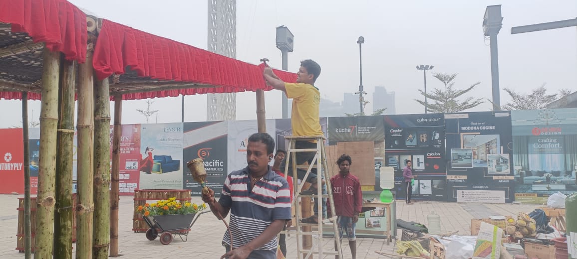 Worker on ladder nailing the valance while another holds a brass lamp
